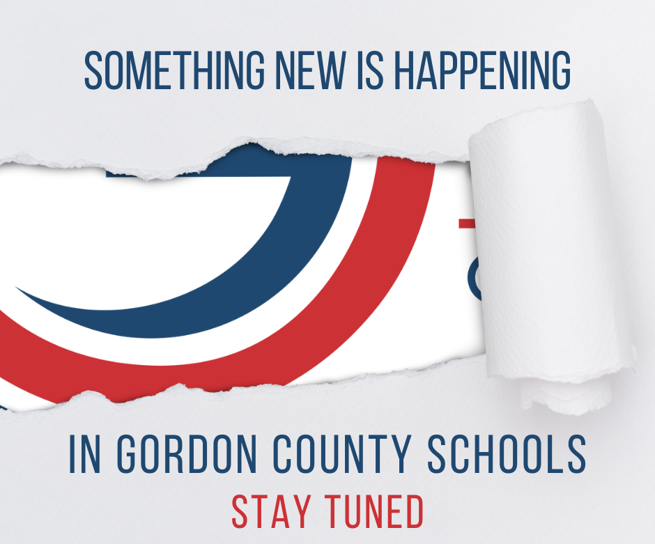 Ripped Paper that states "Something New is Happening in Gordon County Schools.. Stay Tuned" with a partially hidden image in the background