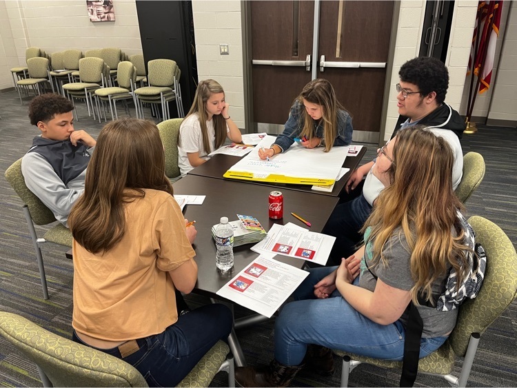 a group of students drafting ideas on a sheet
