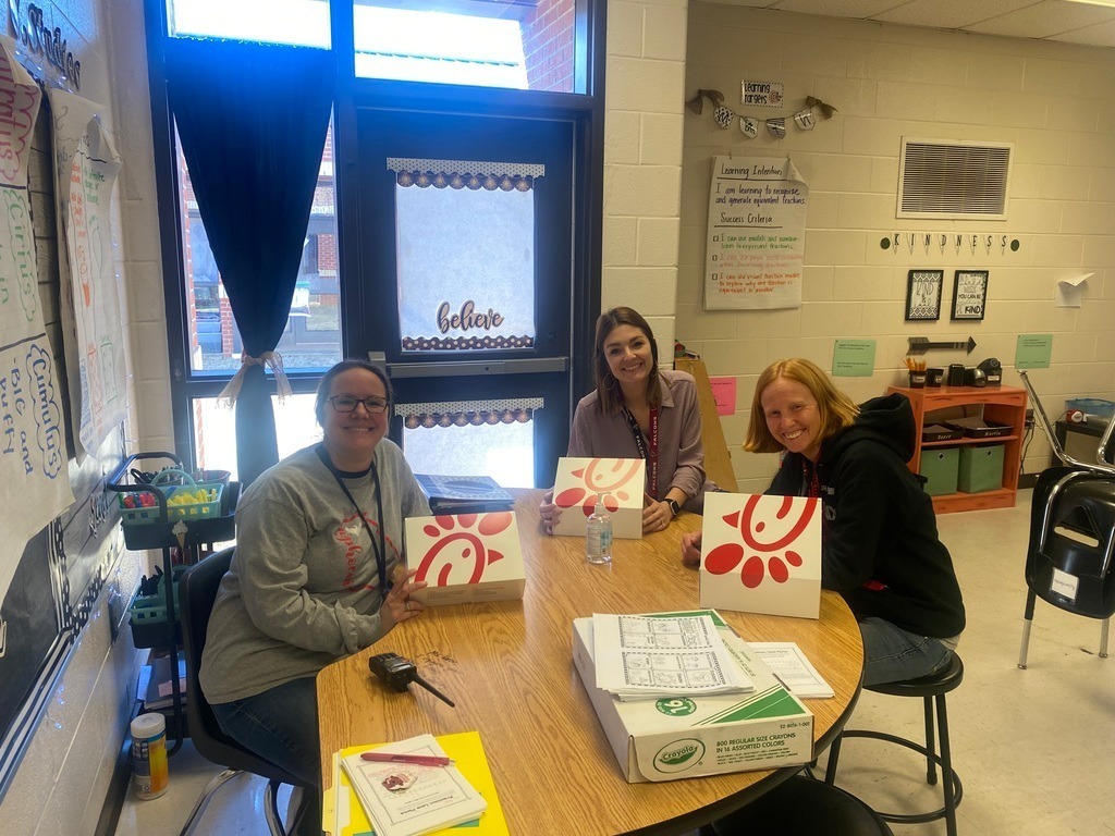 3 teachers sit together eating a box lunch