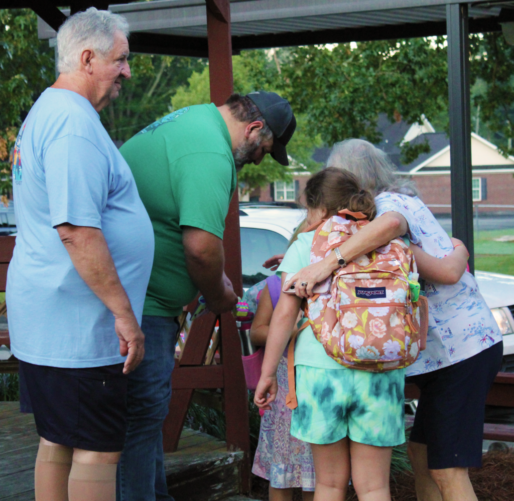 Non-informative: aA family hugs their students before school begins 