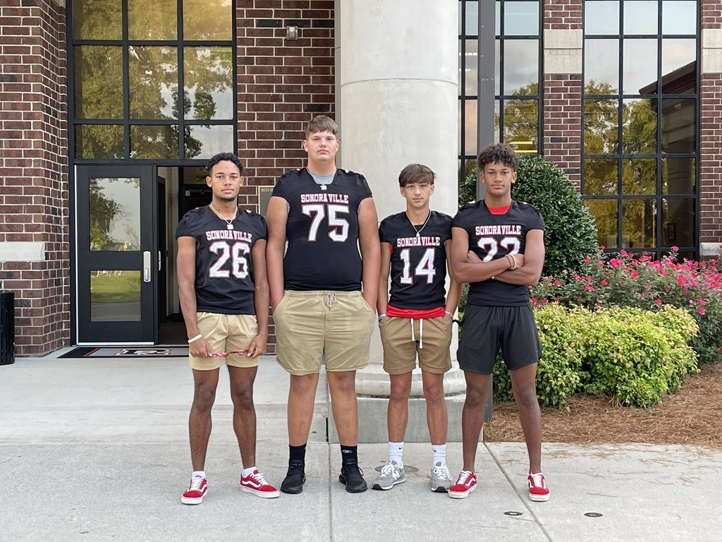 Non-informative: a group of football players stand together for a photo
