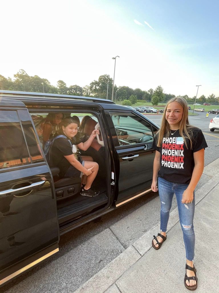 Non-Informative: Students stand together to pose for a picture in the car rider line