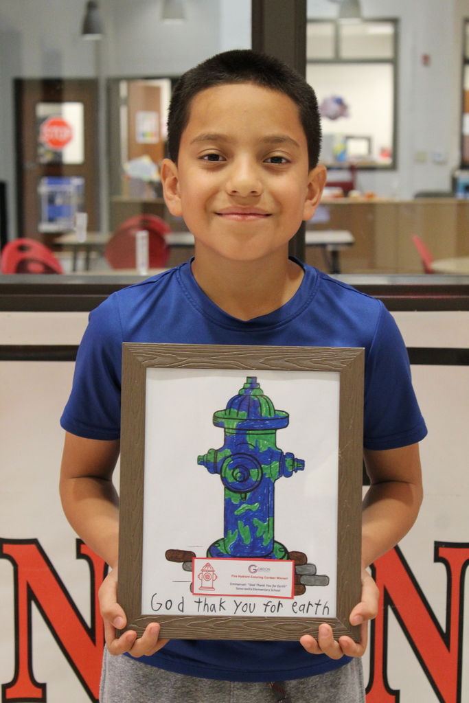 student stands with a fire hydrant he designed