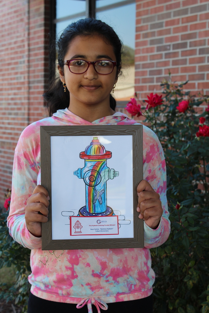 student stands with a fire hydrant she designed