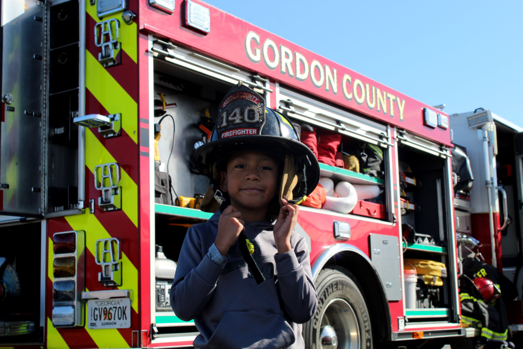 a boy in front of a fire truck