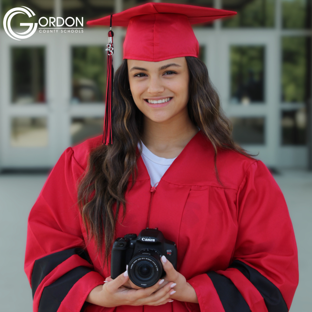A student stands with a camera