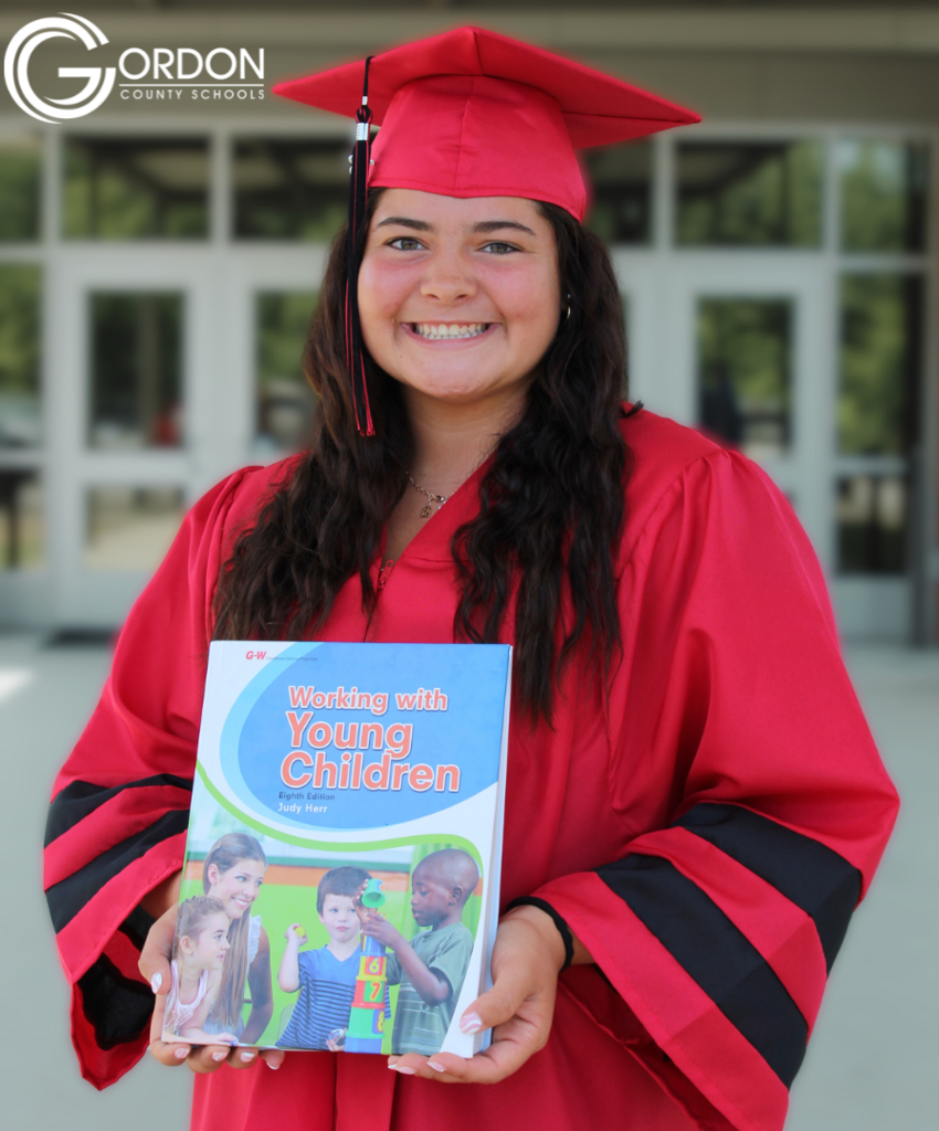 a student stands with a book