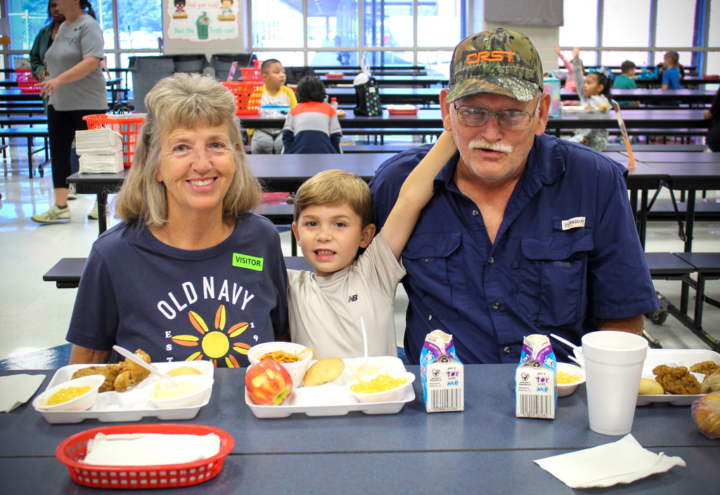 grandparents smile together at a lunch with a child