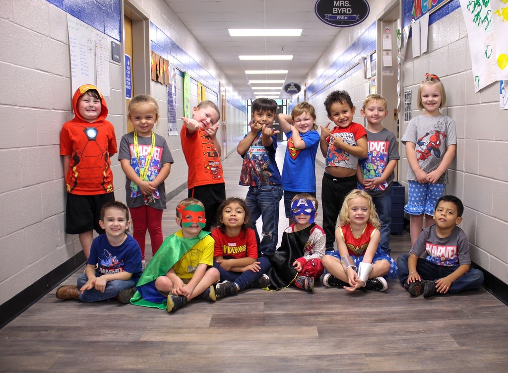 a group of kids dressed as superheroes smile for a picture